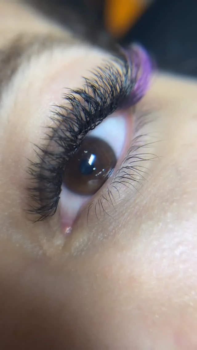 Extensão de pestanas volumosa com detalhe de cor roxa
